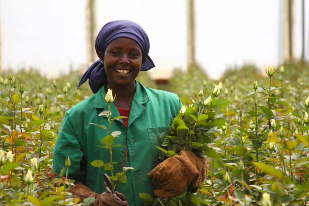 Vrouw die voor fairtrade met bloemen poseert
