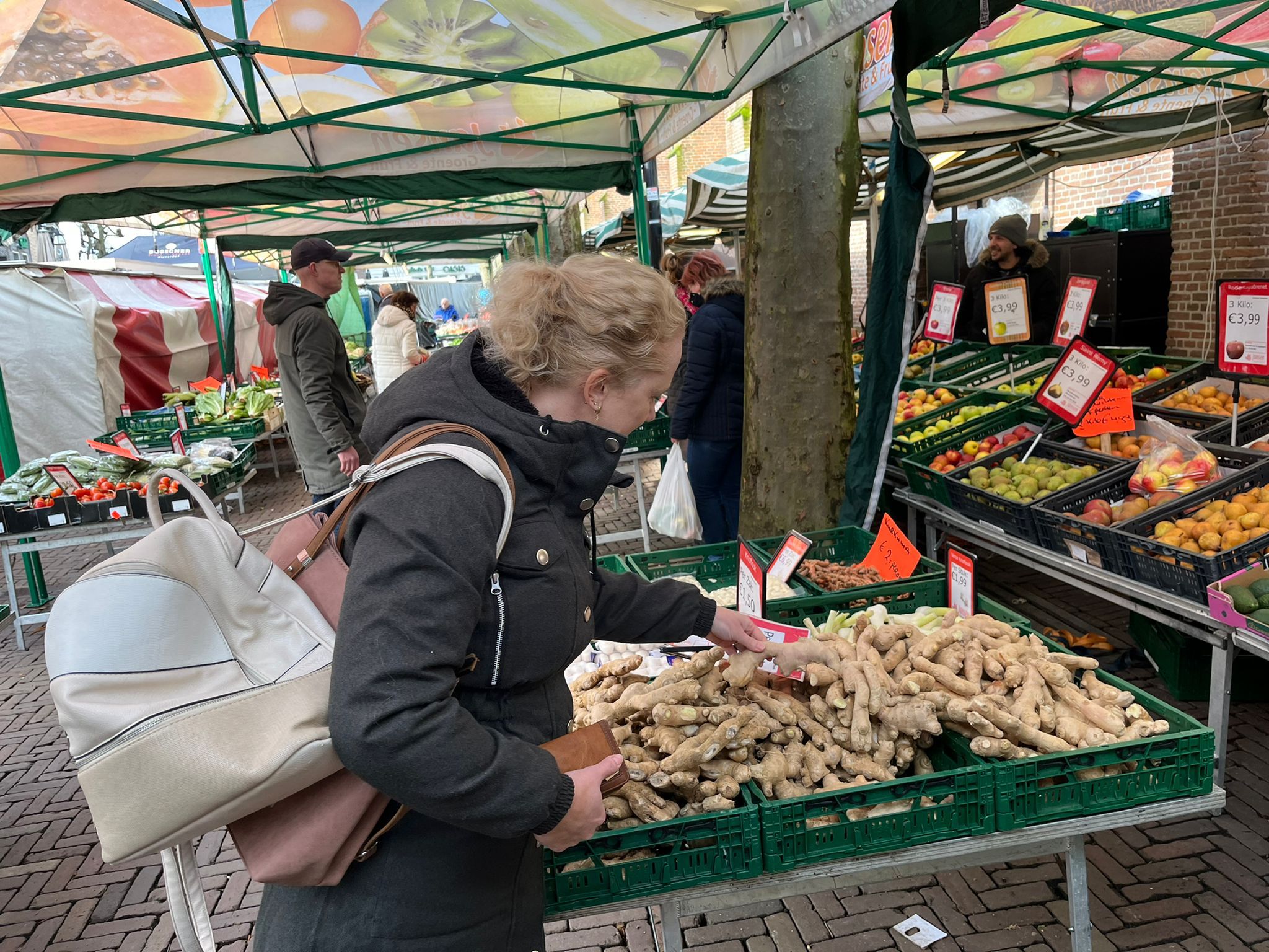 Een vrouw bij een groentekraam op de markt in Meppel
