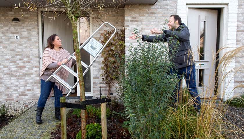 Twee buren die de ladder van elkaar lenen in het kader van circulair Meppel deelt