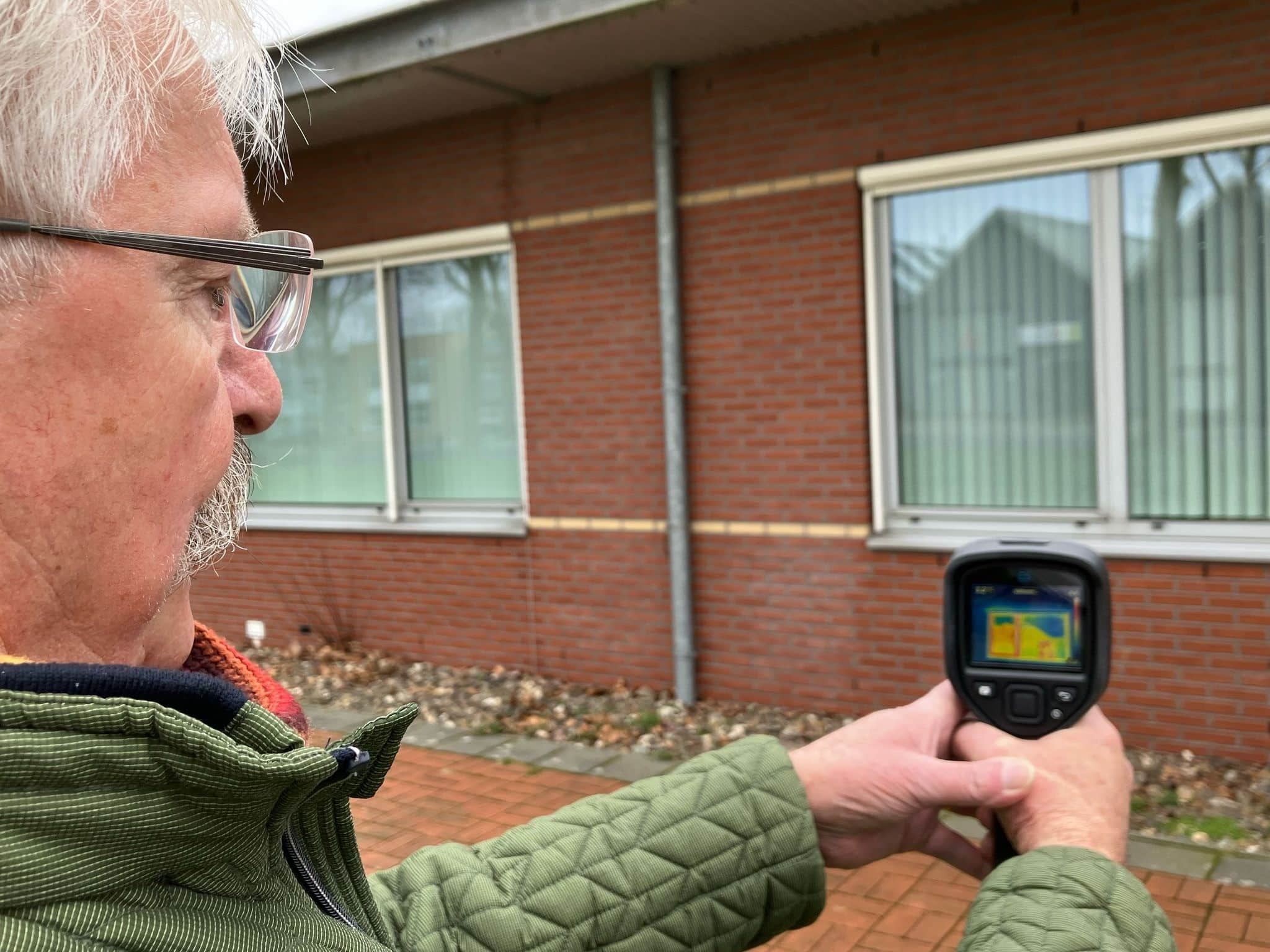 Meppeler energiecoach die een warmtescan maakt van een gebouw