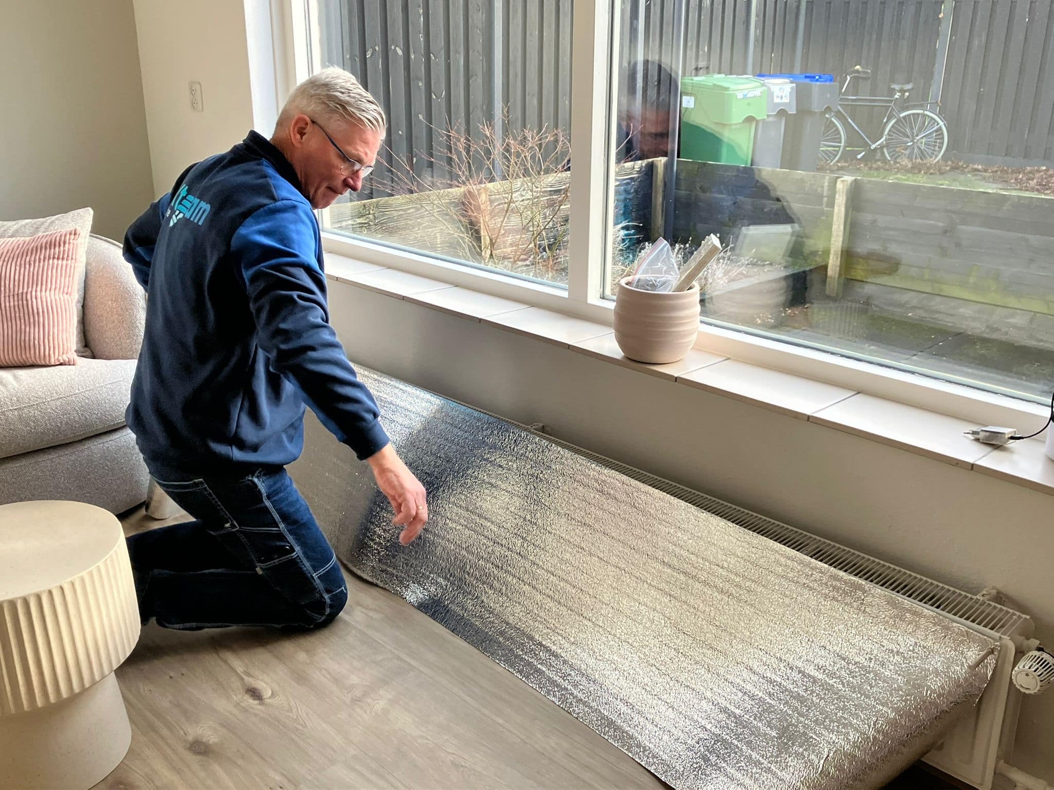 Man brengt radiatorfolie aan