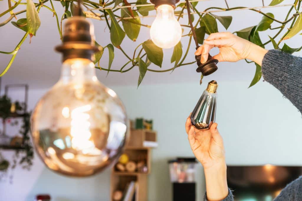 Twee handen die een led lamp indraaien