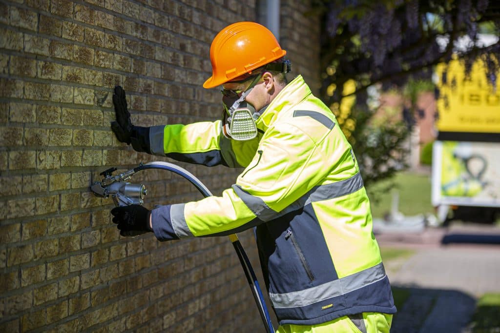 Man die spouwmuurisolatie aanbrengt