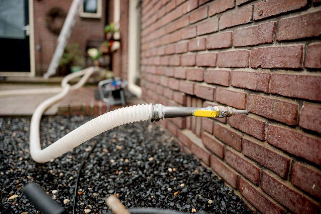 Spouwmuur wordt met een buisje gevuld met isolatie