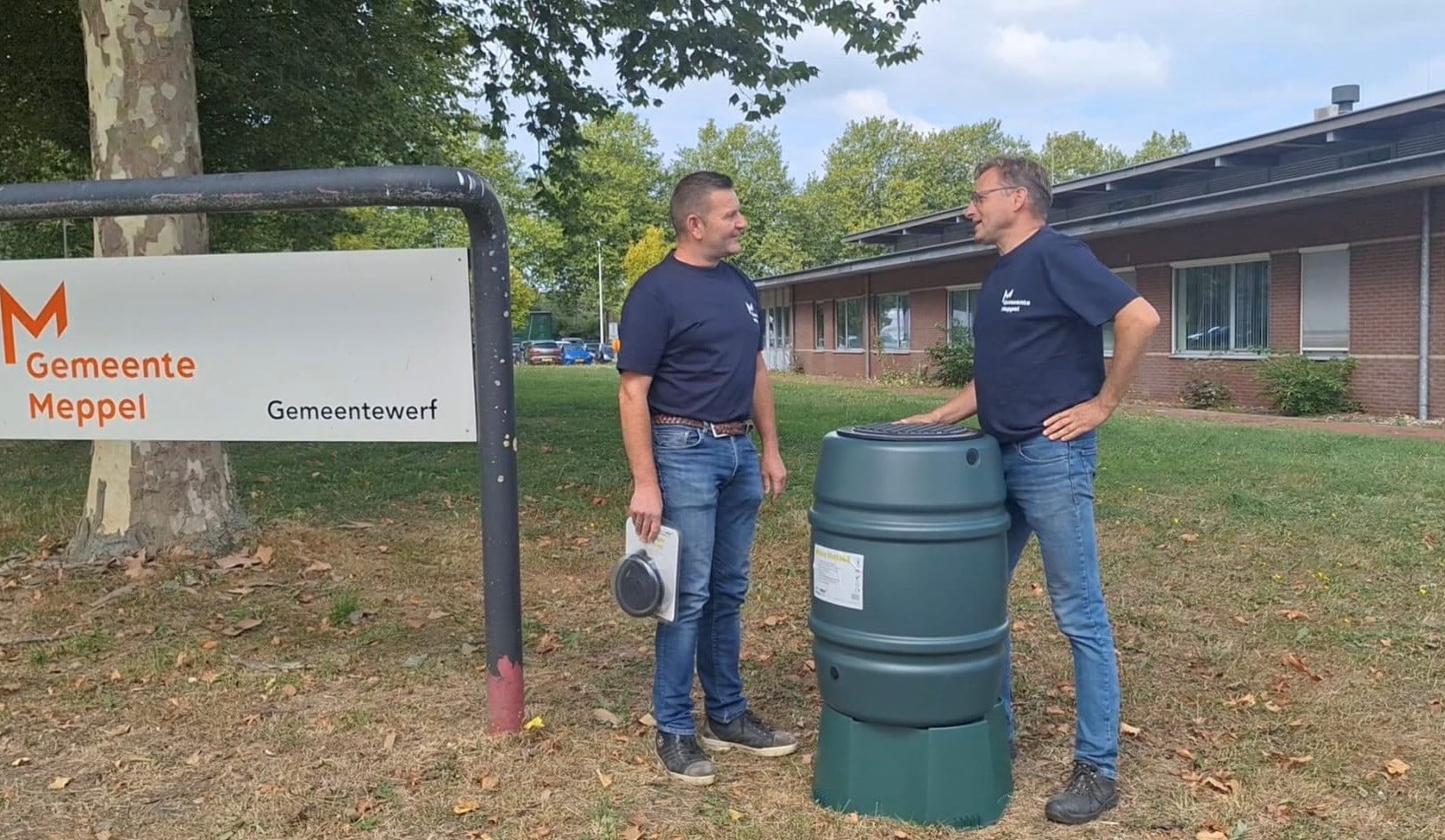Twee medewerkers die de regenton winactie aankondigen in een filmpje